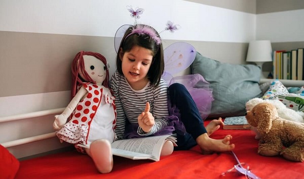 کتاب خواندن کودک با عروسک